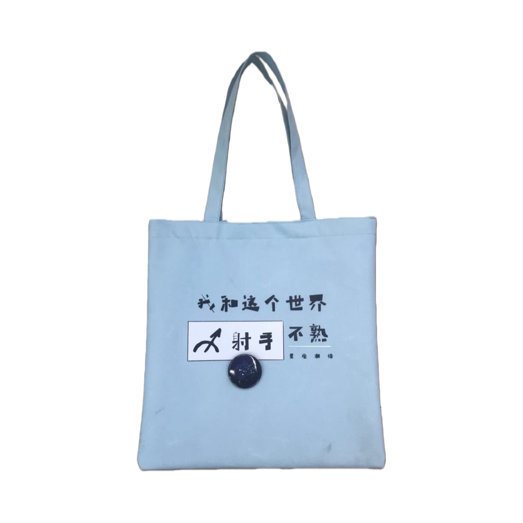 浅蓝色帆布包，主体为印有“我和这个世界不熟”字样及射手座符号的帆布袋白底实物图
