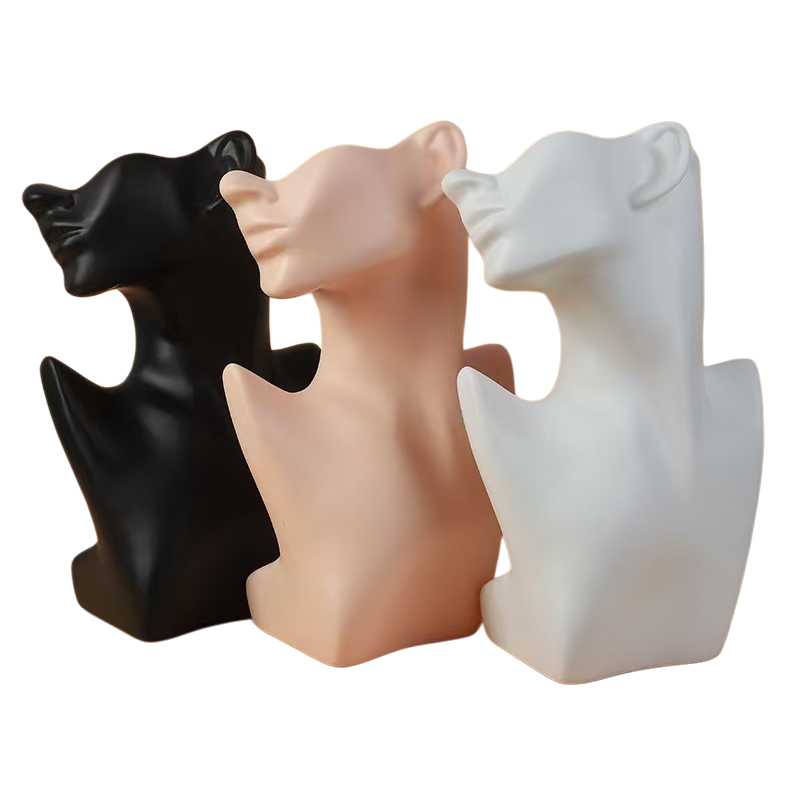 Three abstract sculptures of human heads and necks in black, white and white are arranged in combination Item Picture