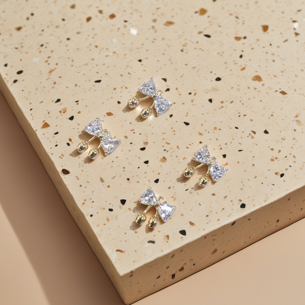 Description: Exquisite bow-shaped ear studs, inlaid with transparent crystals and golden small balls for decoration. Main body: ear studs Application Scenario