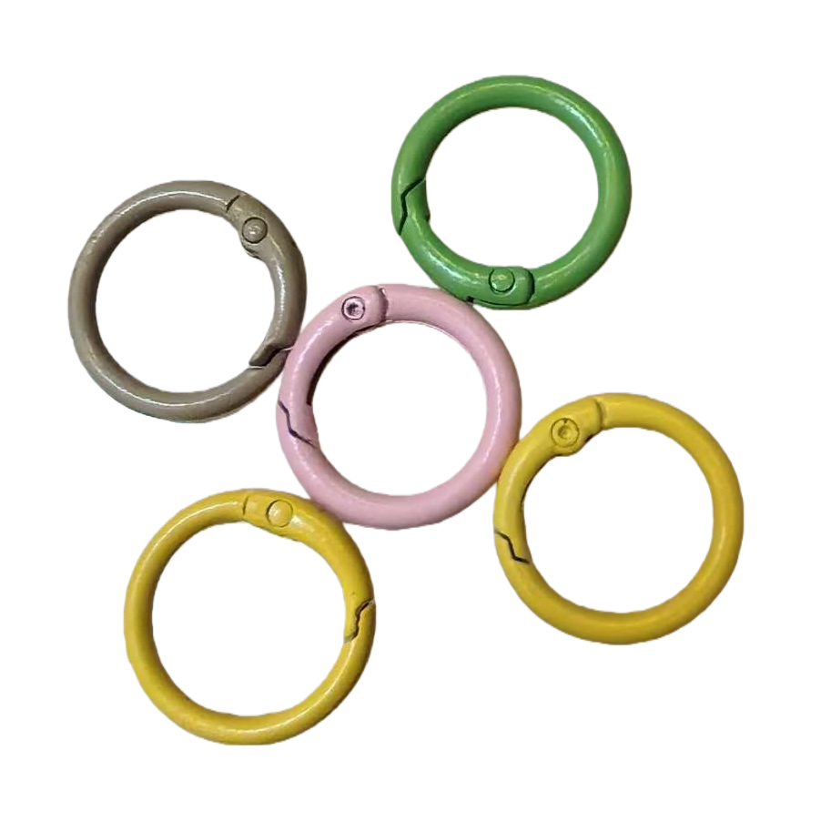 Five colored metal rings in green, pink, yellow and silver with a light background Item Picture