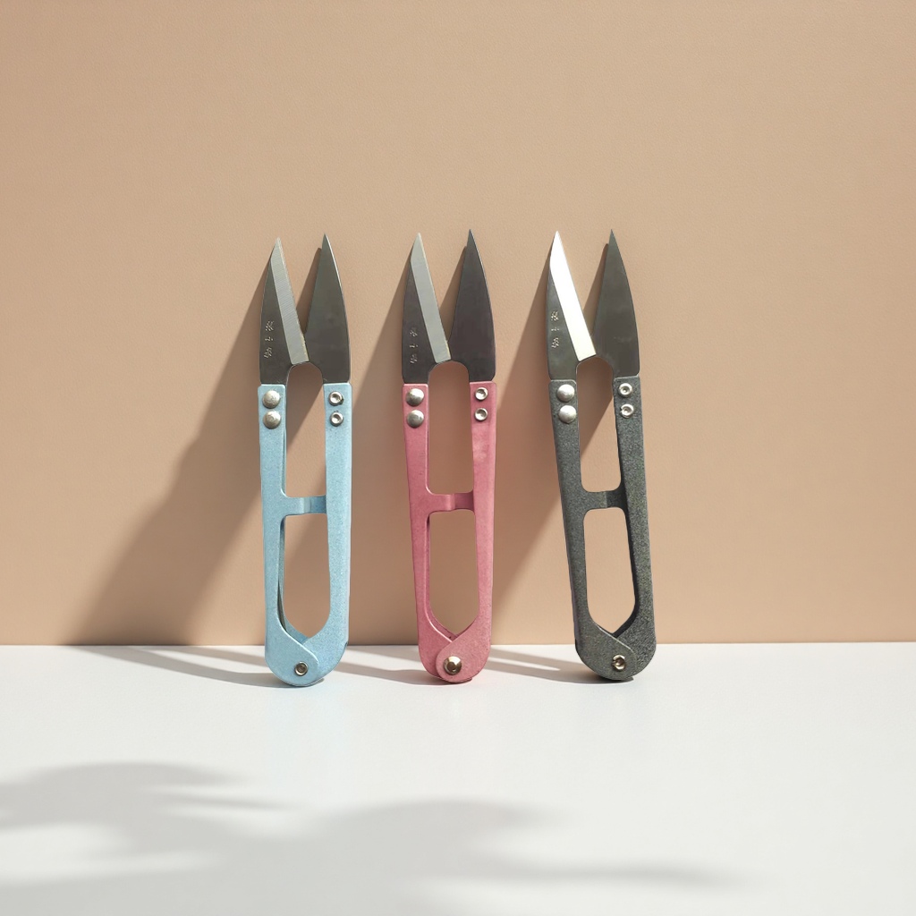 Three sets of colored scissors, blue, pink and grey household cutting tools