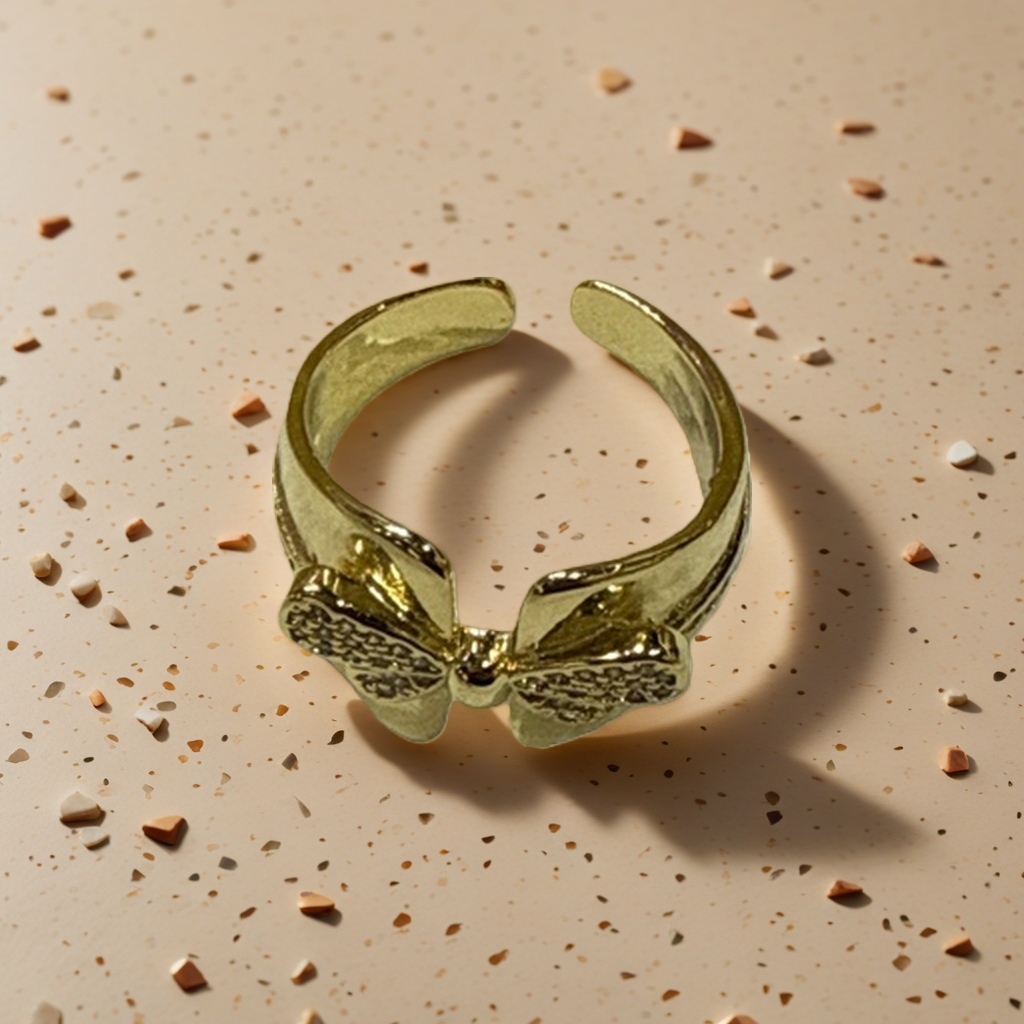 A golden bow-shaped ring is a fashionable and simple ladies' accessory