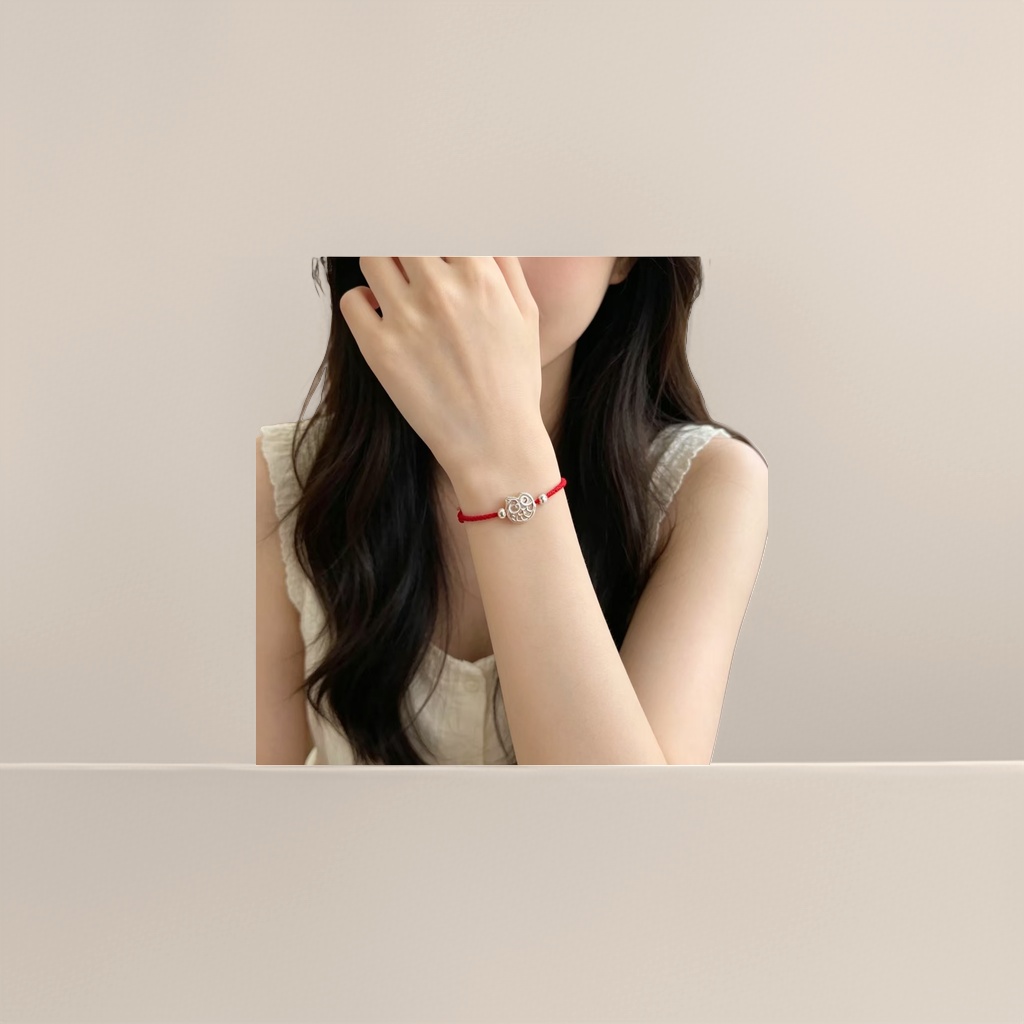 A fashionable and simple couple's style with a red rope bracelet and a silver owl pendant