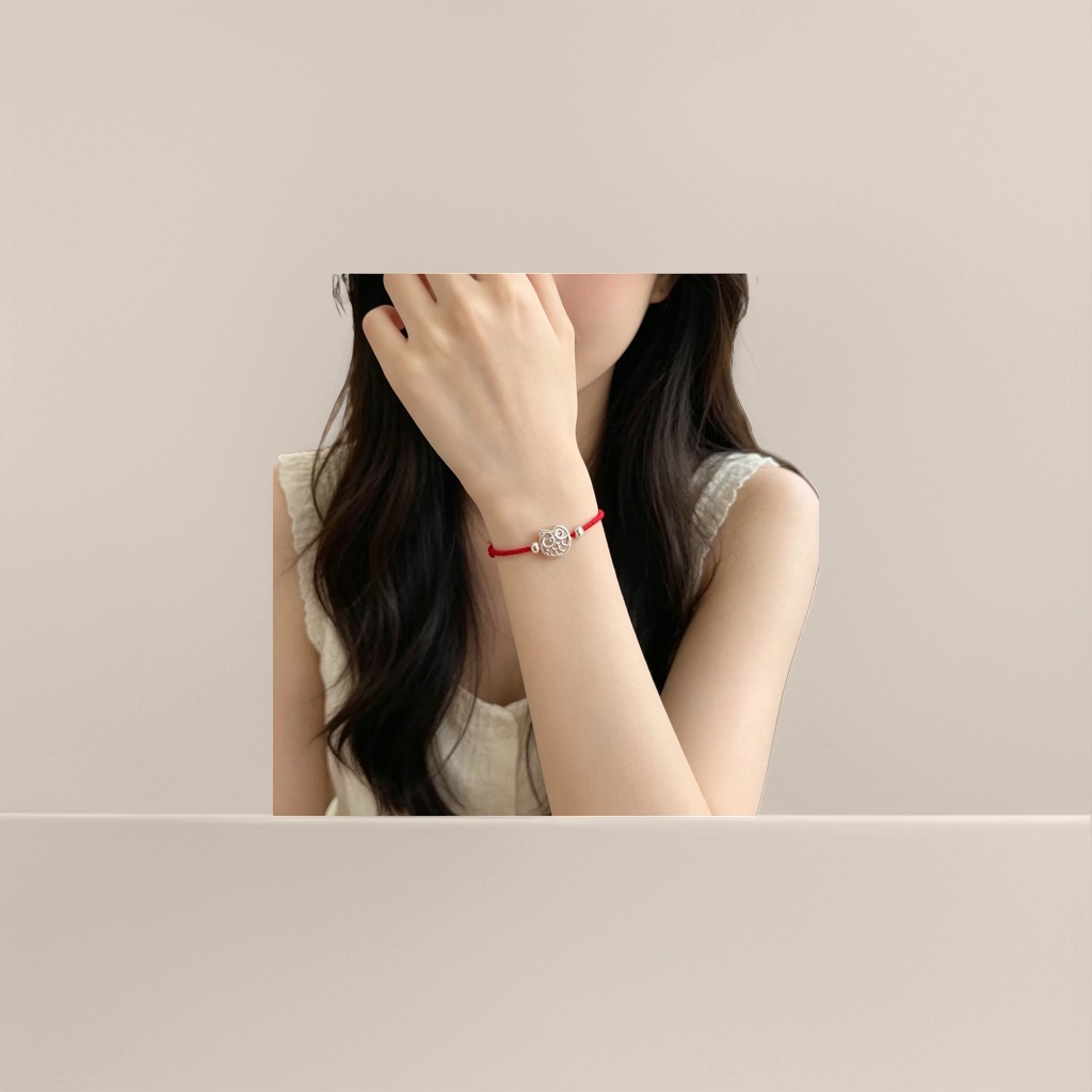 A fashionable and simple couple's style with a red rope bracelet and a silver owl pendant details Picture