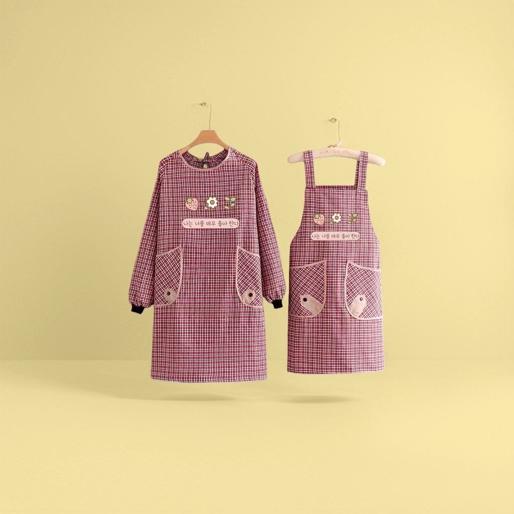 The red and white checkered strawberry Daisy apron features a long-sleeved one-piece design on the left side and a short pocket with a small fish decoration on the right side