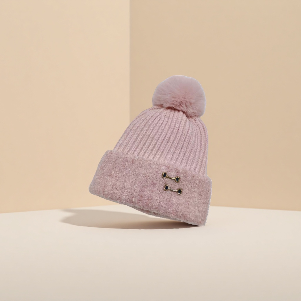 The pink woolen cap has a fluffy ball on the top, a brim and black gold metal fasteners details Picture
