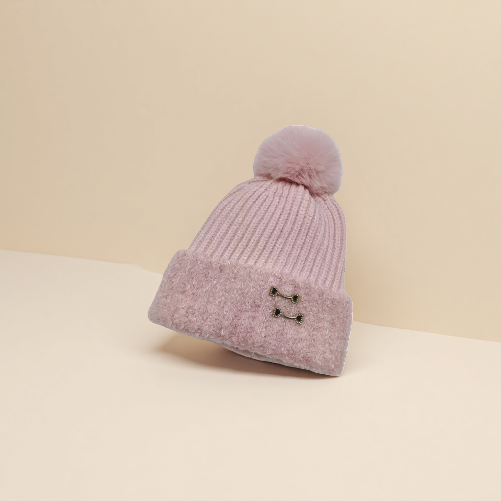 The pink woolen cap has a fluffy ball on the top, a brim and black gold metal fasteners Specification image