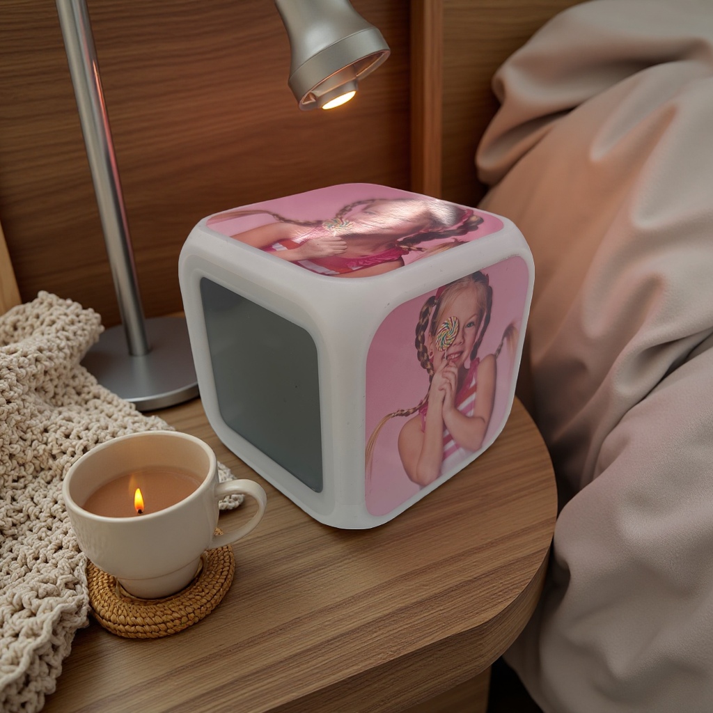 A white cubic alarm clock with a pattern of a girl eating lollipops, a silent bedside display in the bedroom, heat transfer printing details Picture