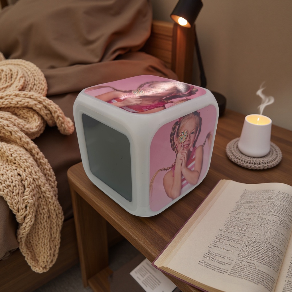 A white cubic alarm clock with a pattern of a girl eating lollipops, a silent bedside display in the bedroom, heat transfer printing Application Scenario