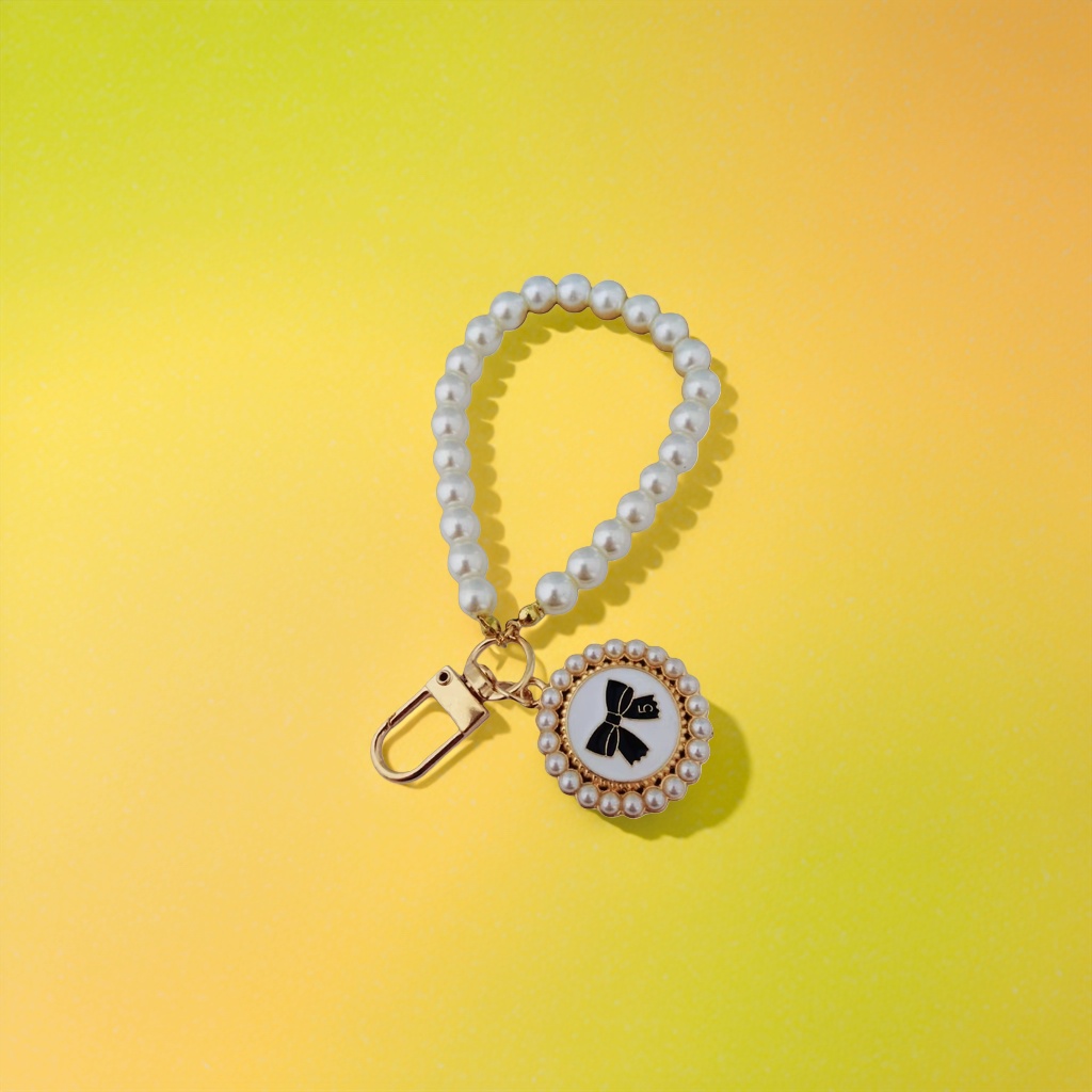 Pearl necklace keychain with golden clasp, black bow, white background round plate and pearl inlaid on the outer circle