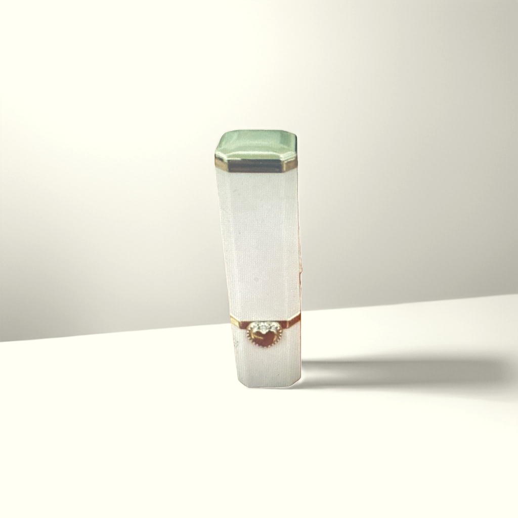 A white lipstick tube with a green cap and golden heart-shaped decoration