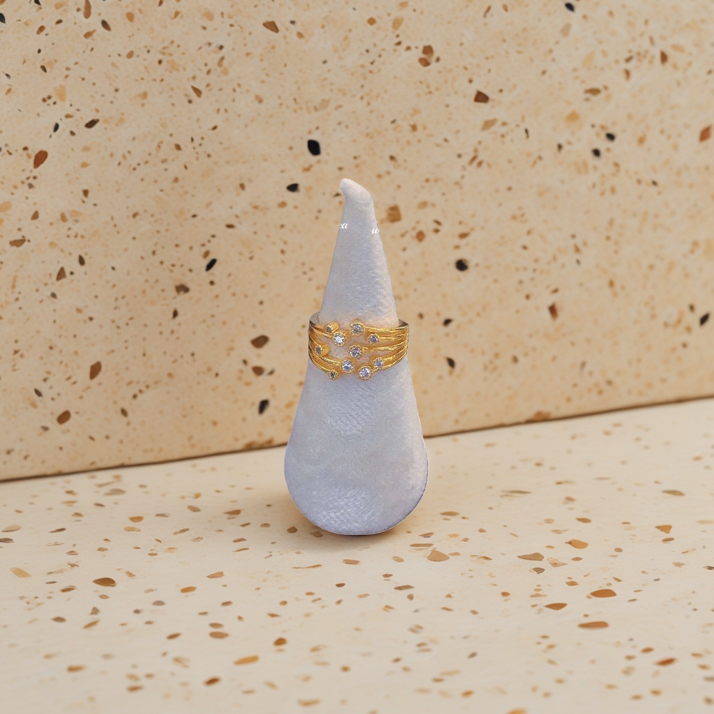 A golden multi-layered diamond ring paired with a white suede ring setting in a fashionable and light luxury gift box