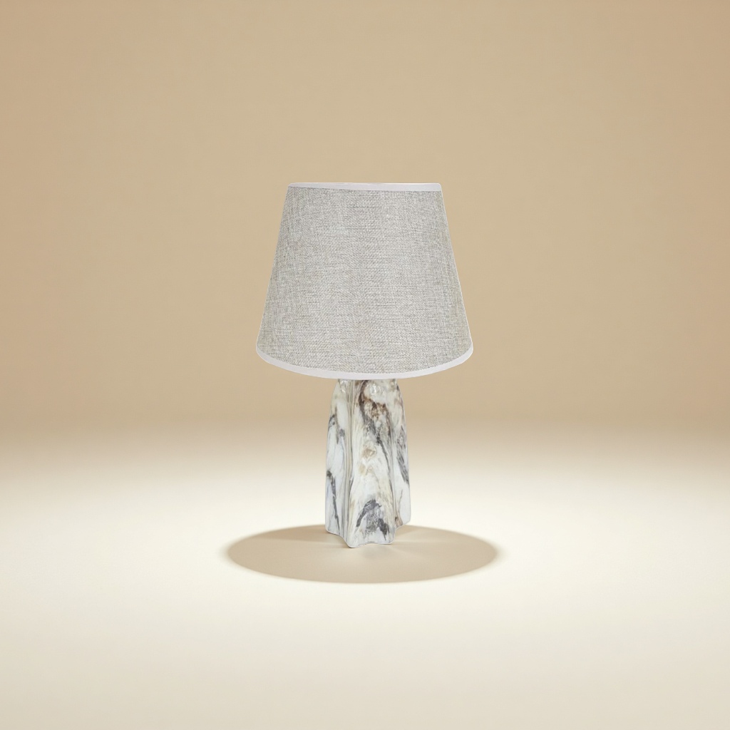 A beige fabric lampshade paired with a marble-patterned lamp base table lamp