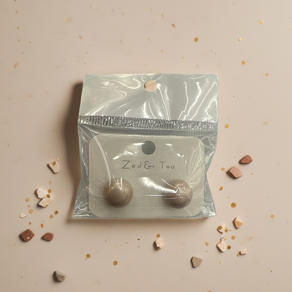 Zed & Two beige ear studs are packaged in transparent plastic bags with brand labels