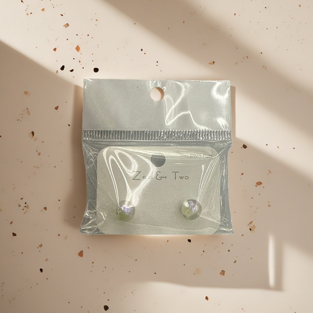Zed & Two pearl-lustrous round stud earrings are packaged in transparent plastic bags with white card labels details Picture