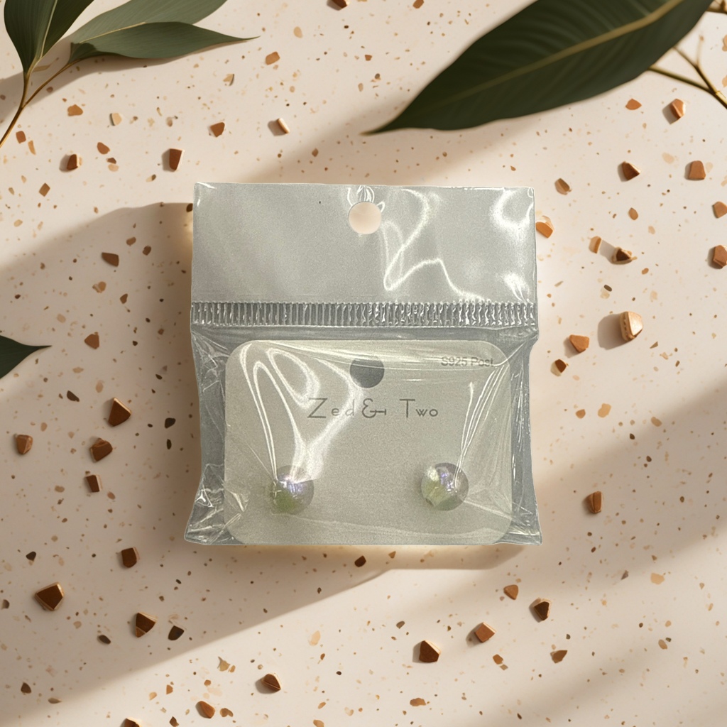 Zed & Two pearl-lustrous round stud earrings are packaged in transparent plastic bags with white card labels Specification image