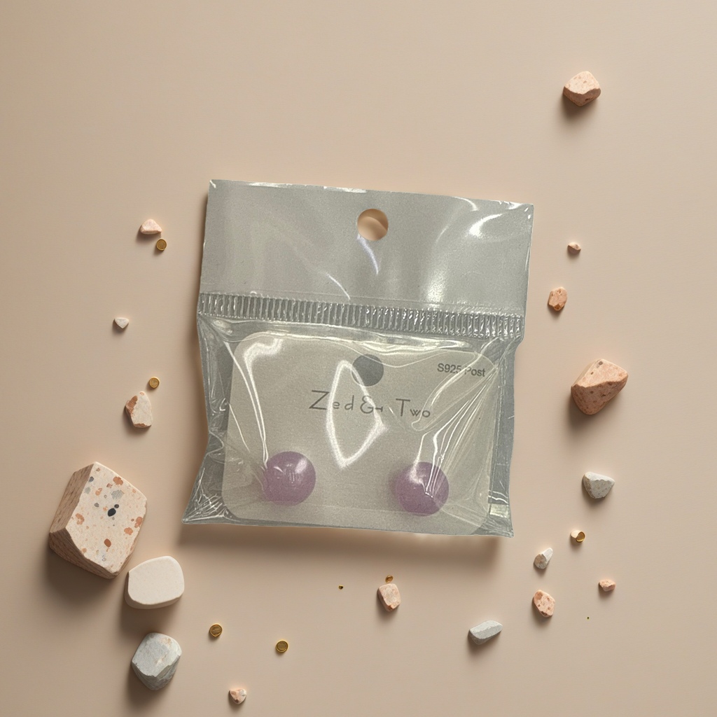 Zed & Two purple round stud earrings are packaged in transparent plastic bags