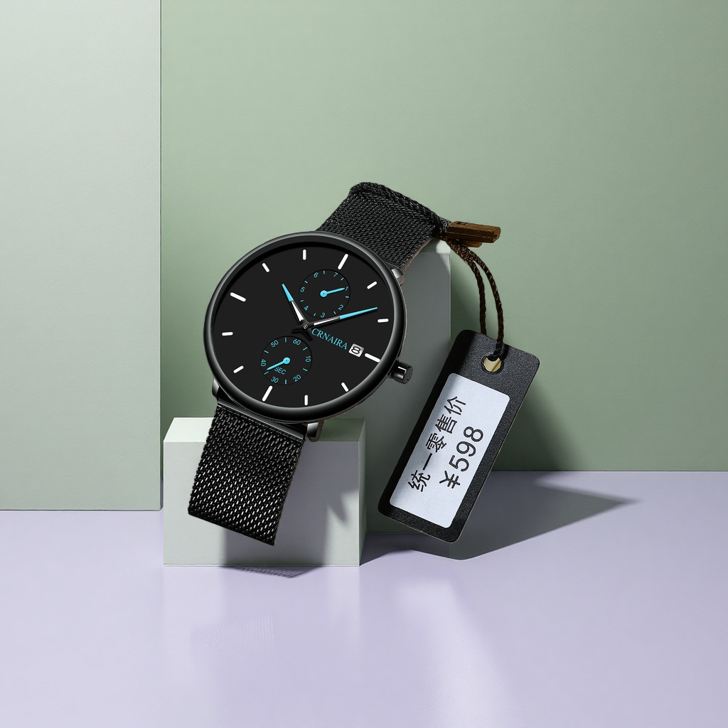 The watch features a black dial with a metal mesh strap and is packaged in a beige leather box