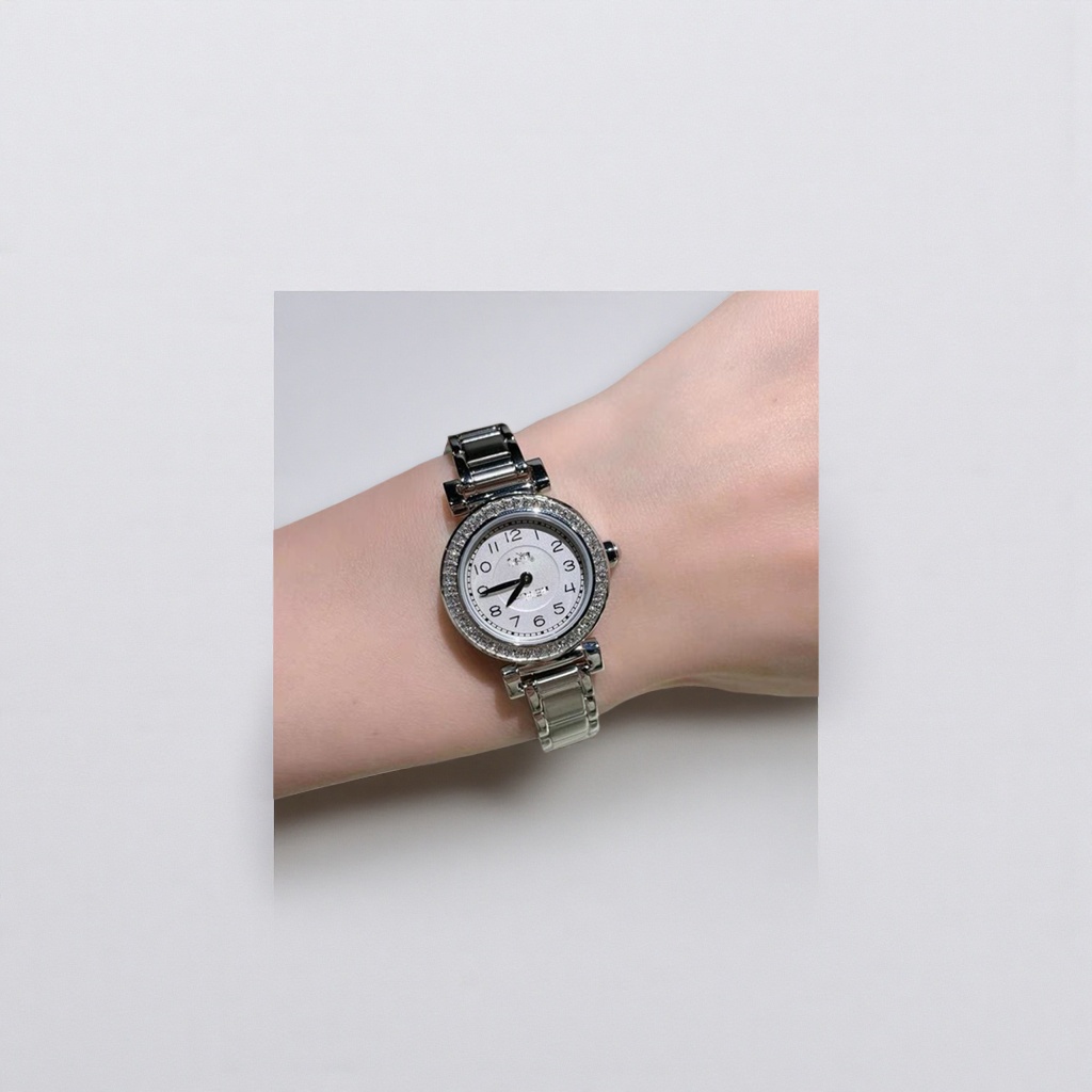 A silver diamond-encrusted women's fashion wristwatch with a light luxury style, worn on the wrist
