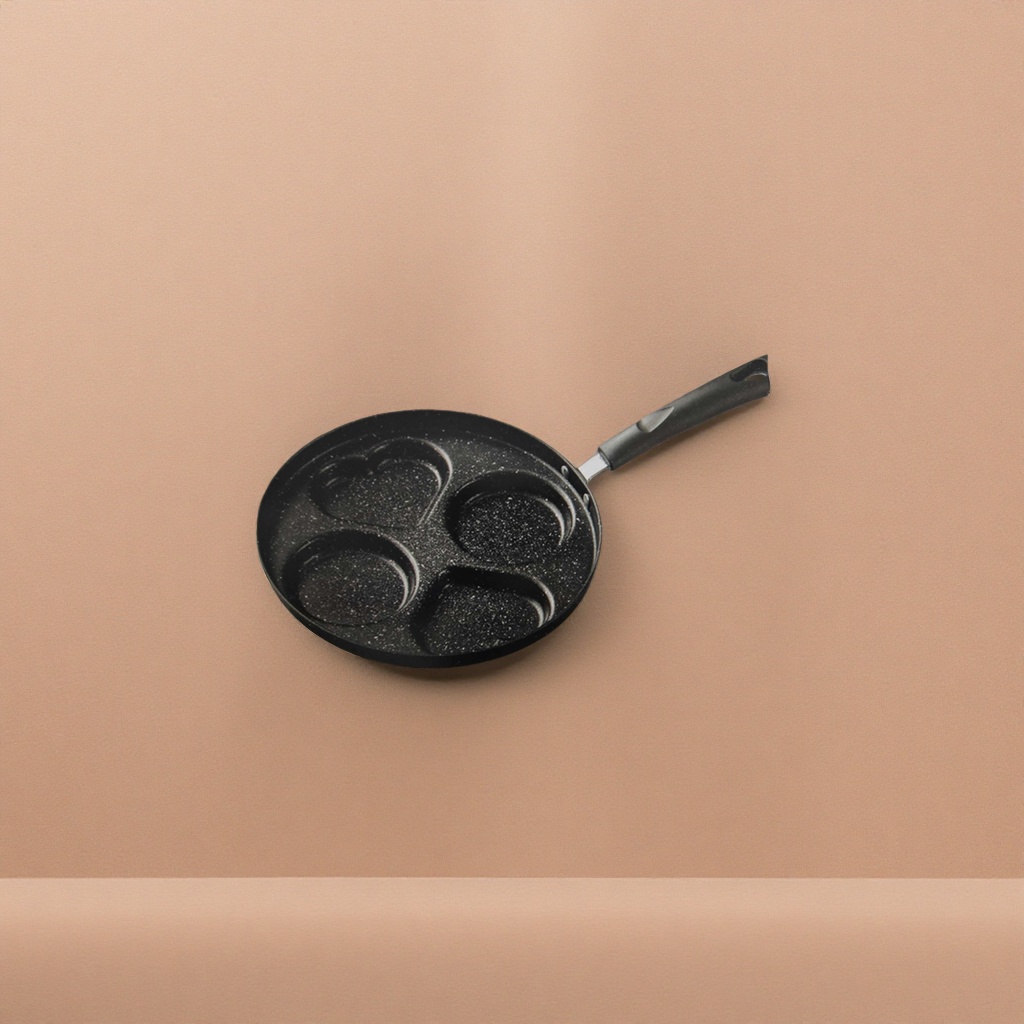 A black-spotted frying pan with a heart-shaped circular groove and a long-handled non-stick pan