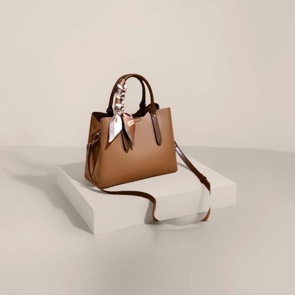 Brown textured handbag with a detachable shoulder strap decorated with a silk scarf