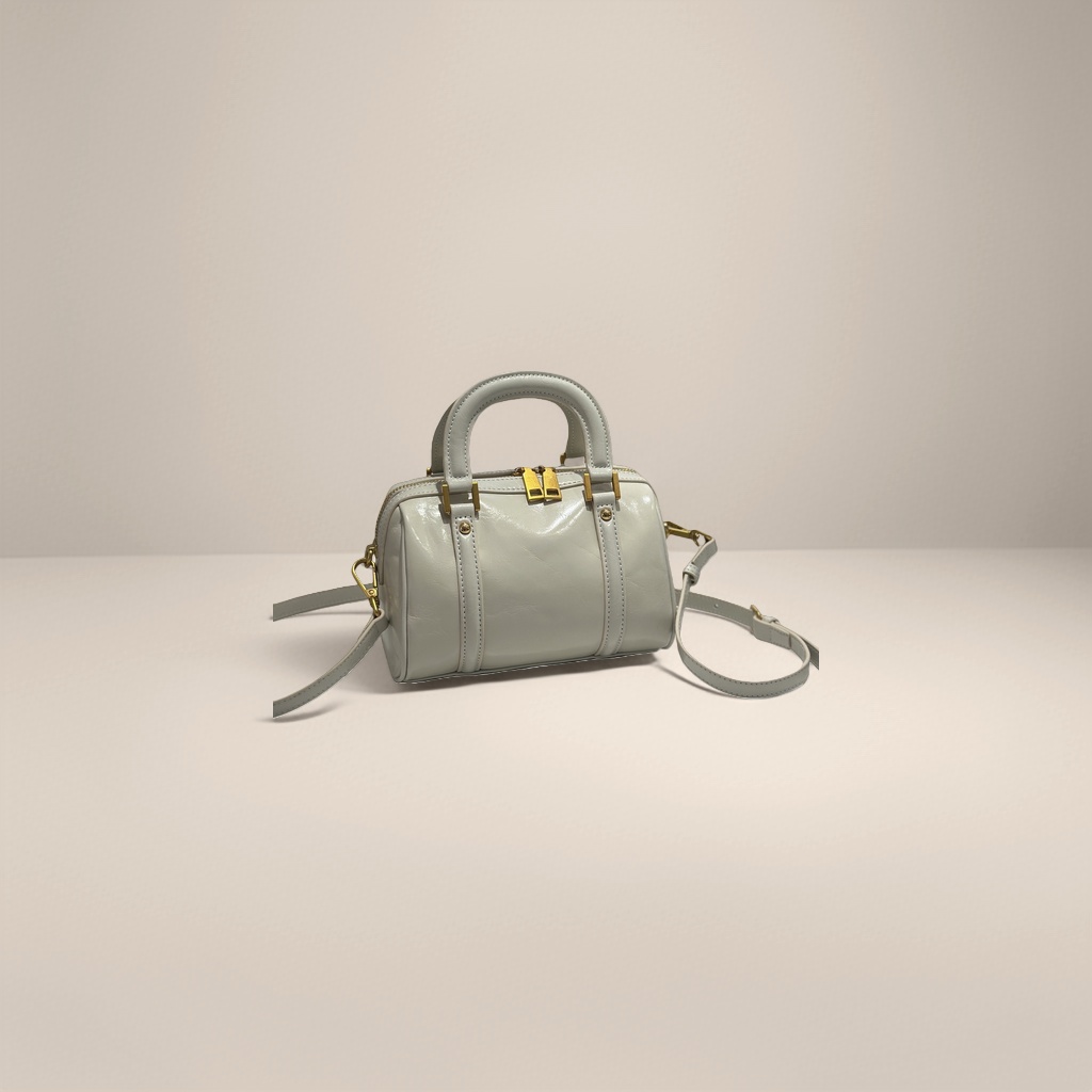 A bright beige handbag with a detachable shoulder strap featuring golden metal fasteners