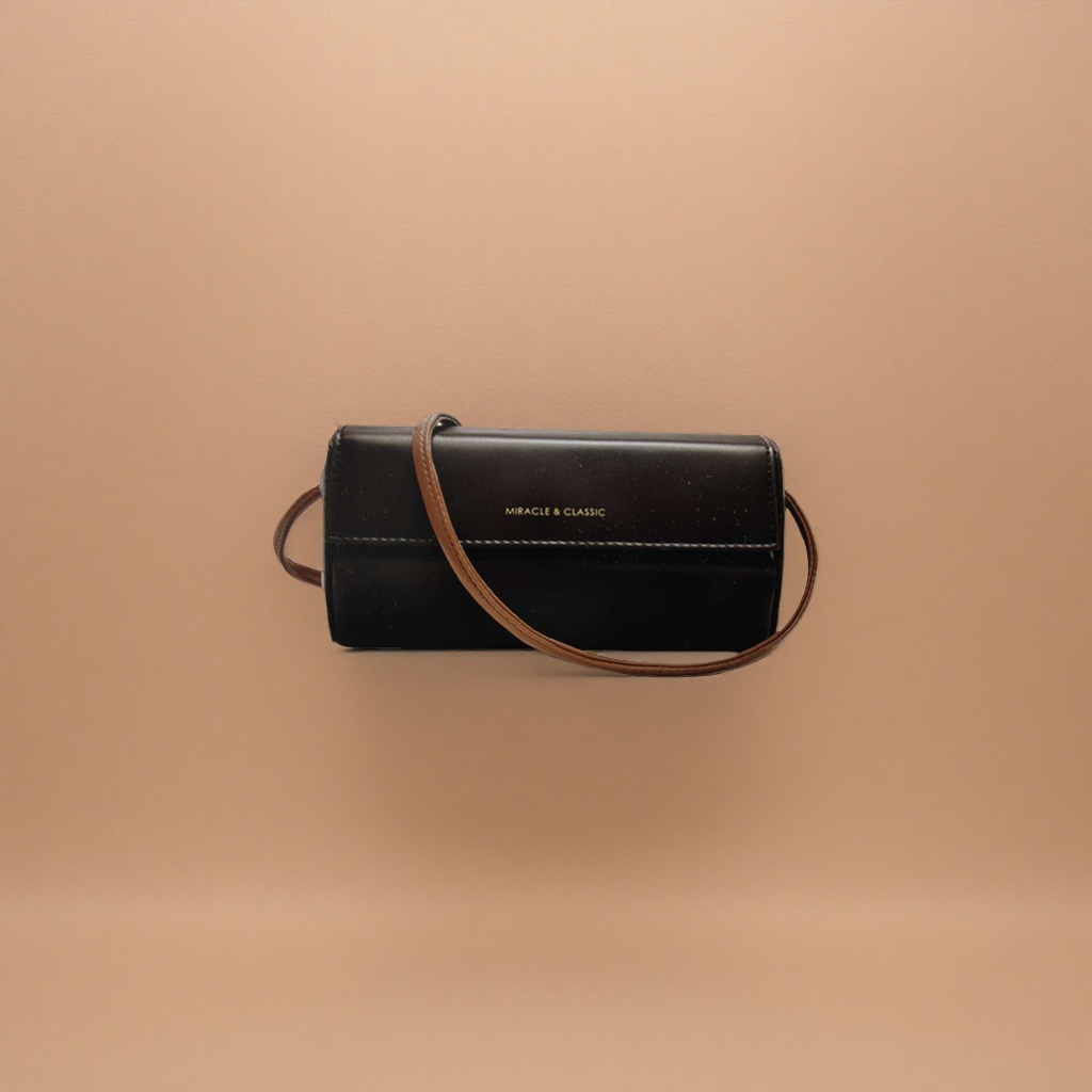 A black leather crossbody bag with a brown shoulder strap and golden MIRACLE & CLASSIC letches on the front Specification image
