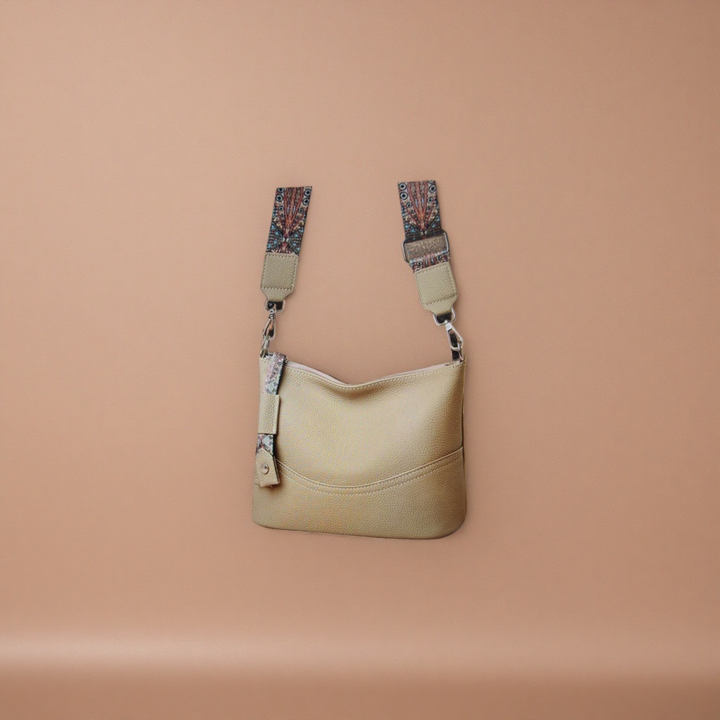 A beige textured leather crossbody bag with a colorful patterned shoulder strap Application Scenario