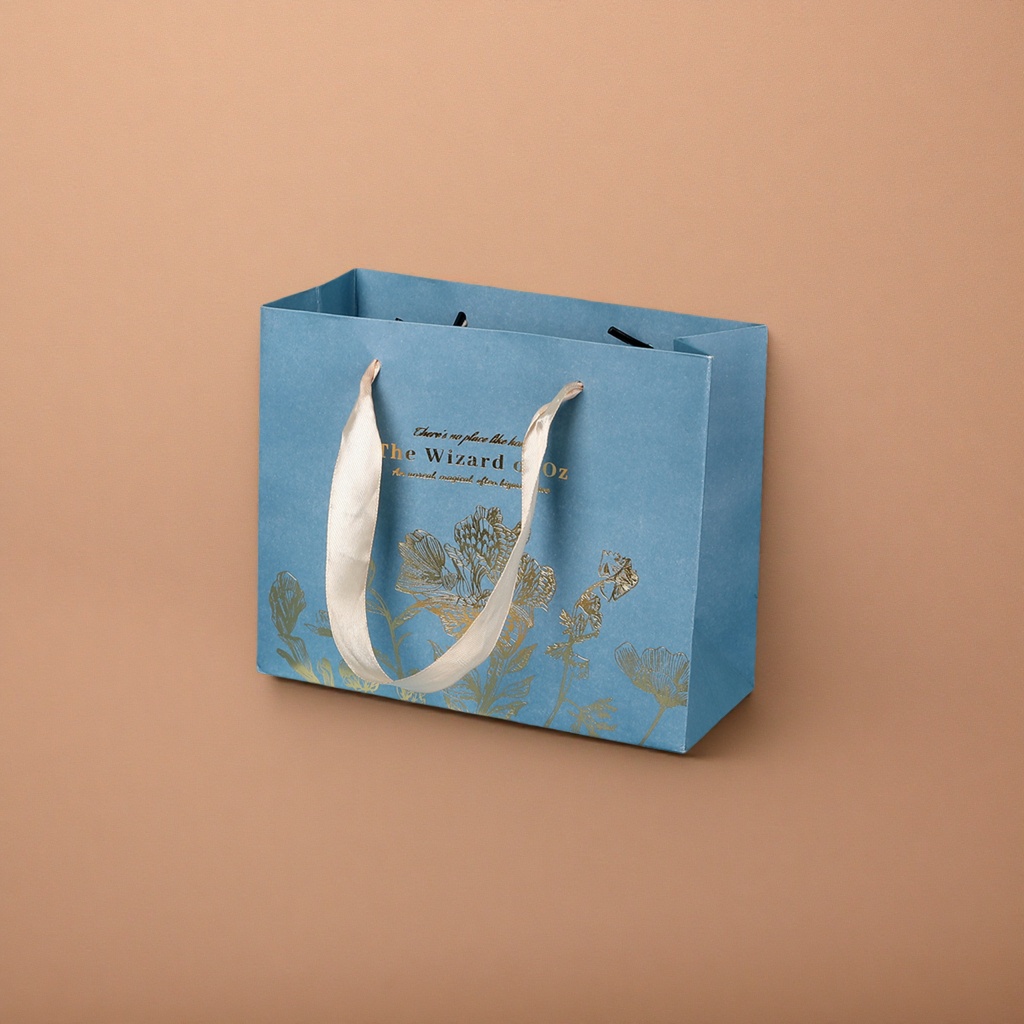 A blue gift bag with a beige ribbon handle featuring golden floral patterns details Picture