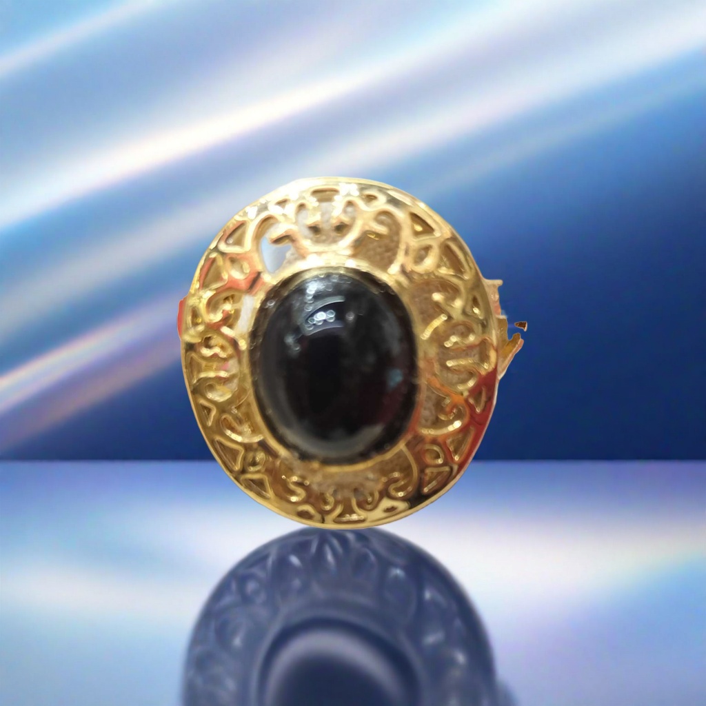 A fashionable and light luxury lady's ring with a golden carved pattern and a black oval gemstone set in the center