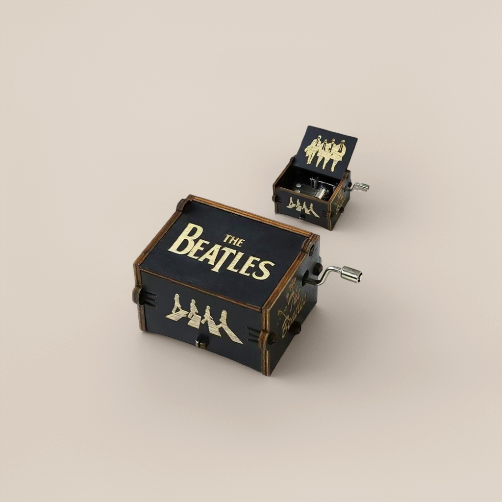 Black wooden "THE BEATLES" music box with golden words and a silhouette pattern of the Beatles