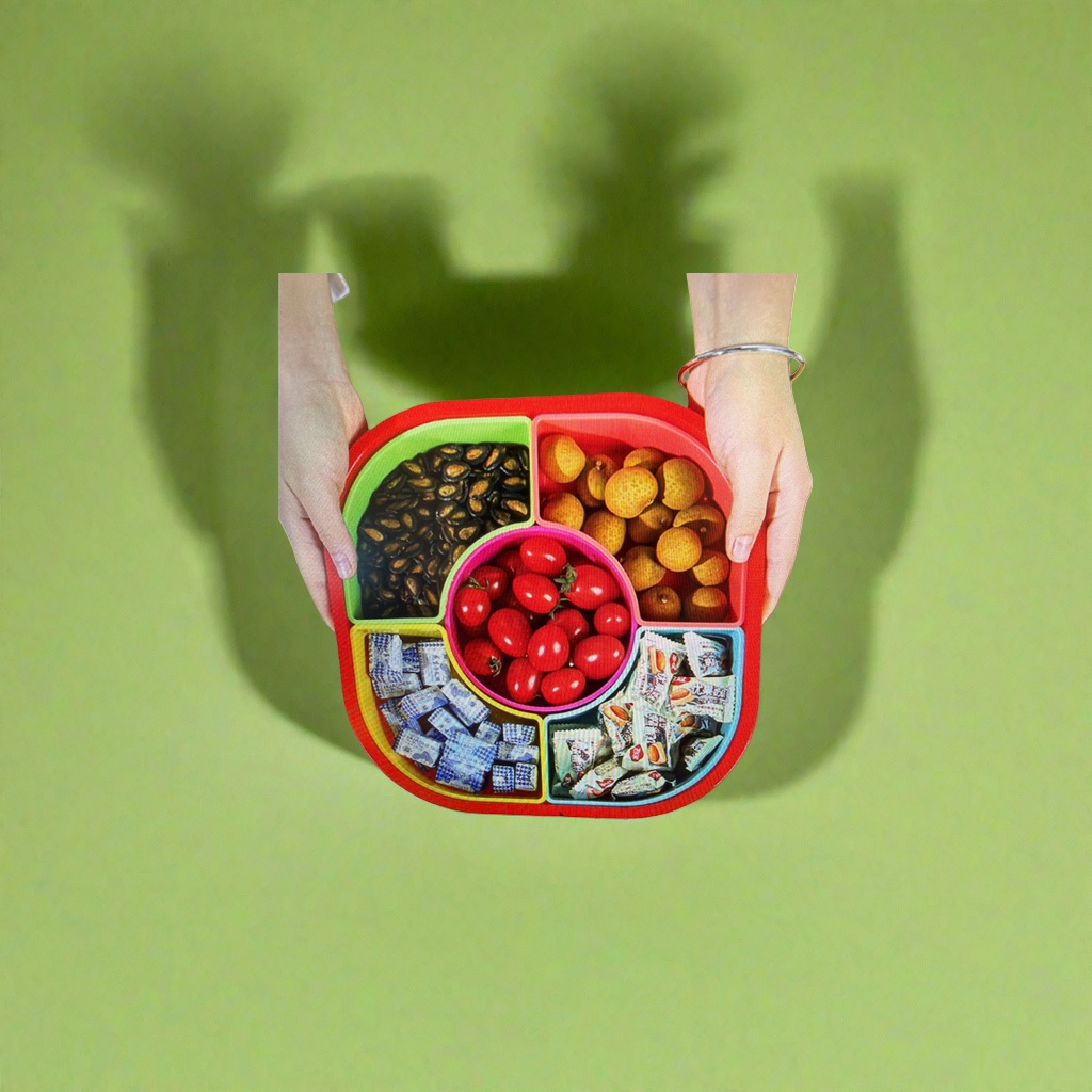 The colorful compartmented fruit plate contains black melon seeds, longans, cherry tomatoes, blue and white packaged candies, and white packaged snacks Application Scenario