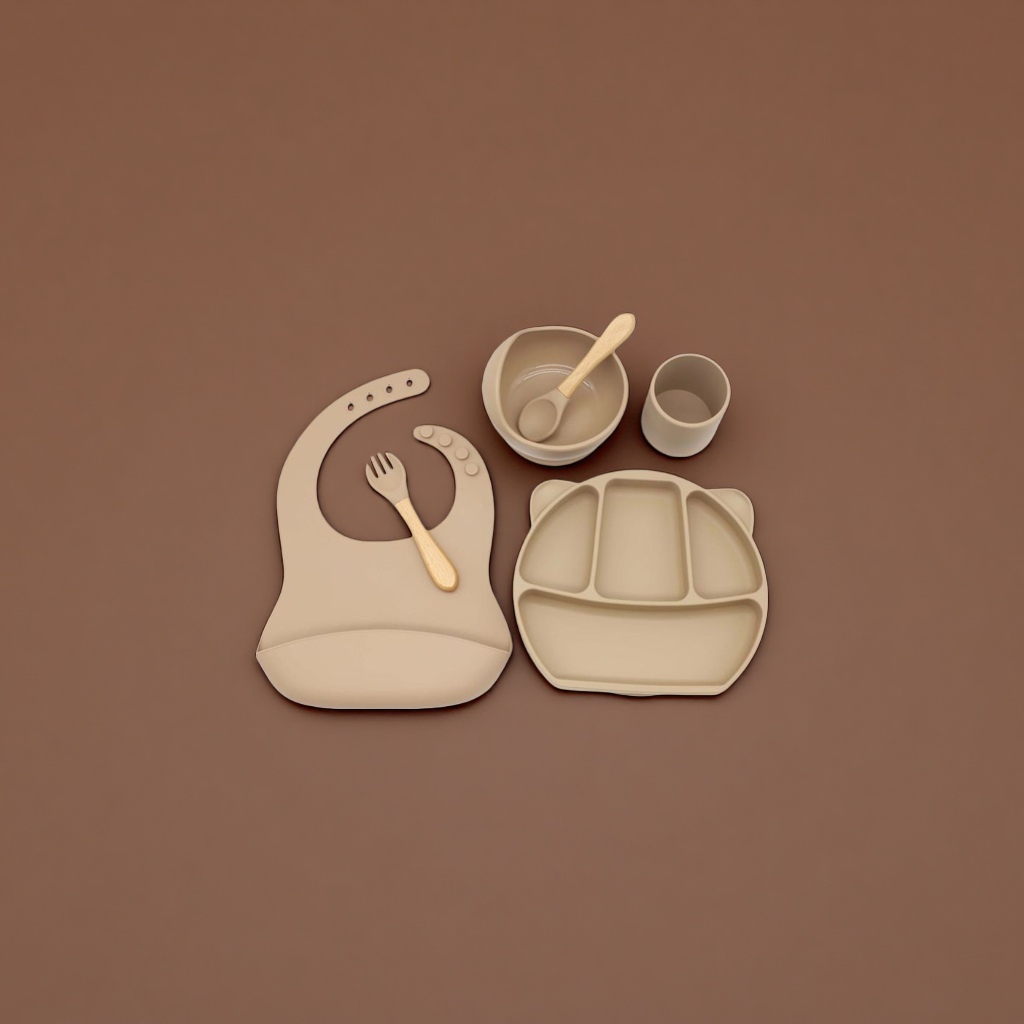 Beige silicone baby tableware set with bibs, compartments, plates, bowls and cups, and wooden handles Application Scenario