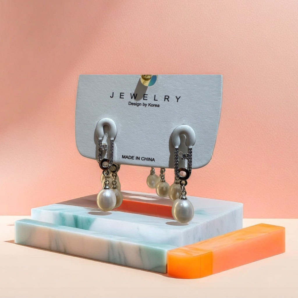 A simple and elegant pair of white stud earrings paired with pearl pendant earrings details Picture