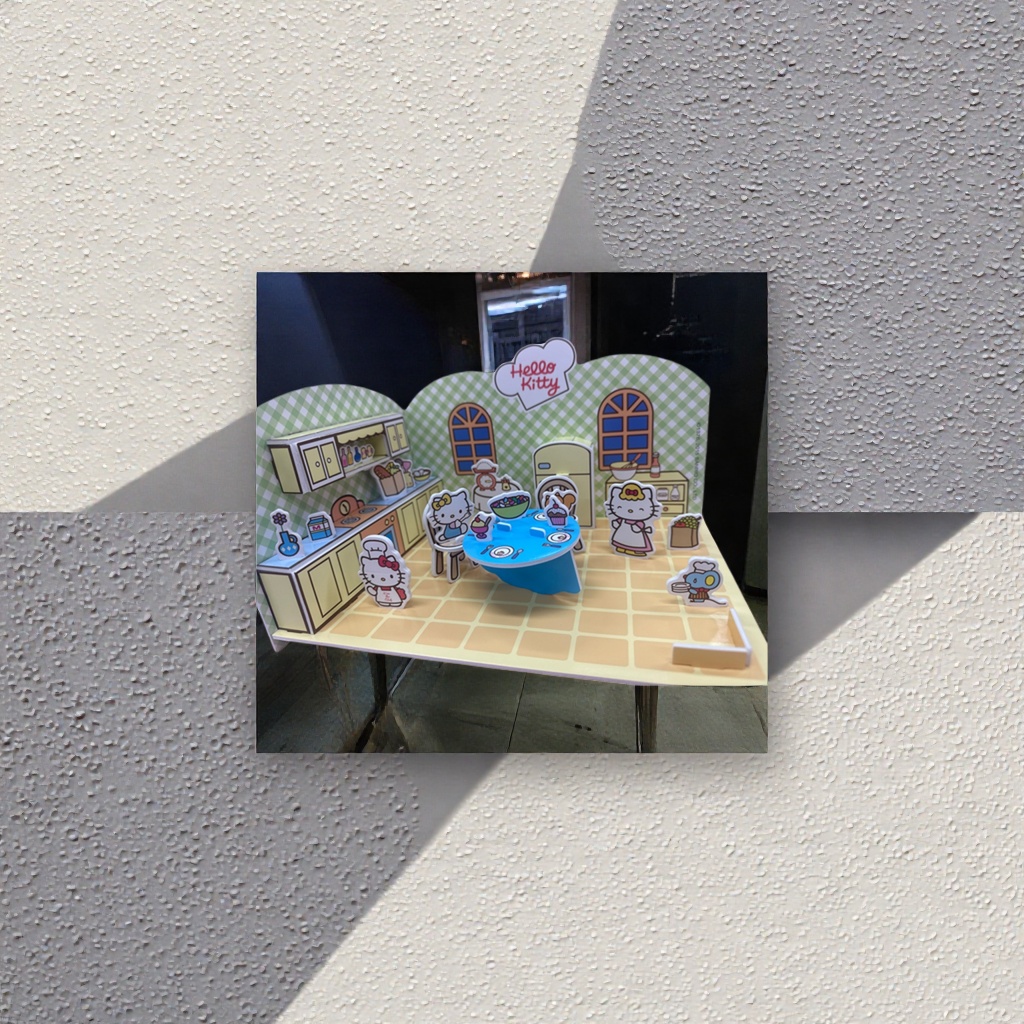 Hello Kitty pink kitchen paper art model with blue dining table, yellow cabinets, green checkered wall and character kitchenware ornaments