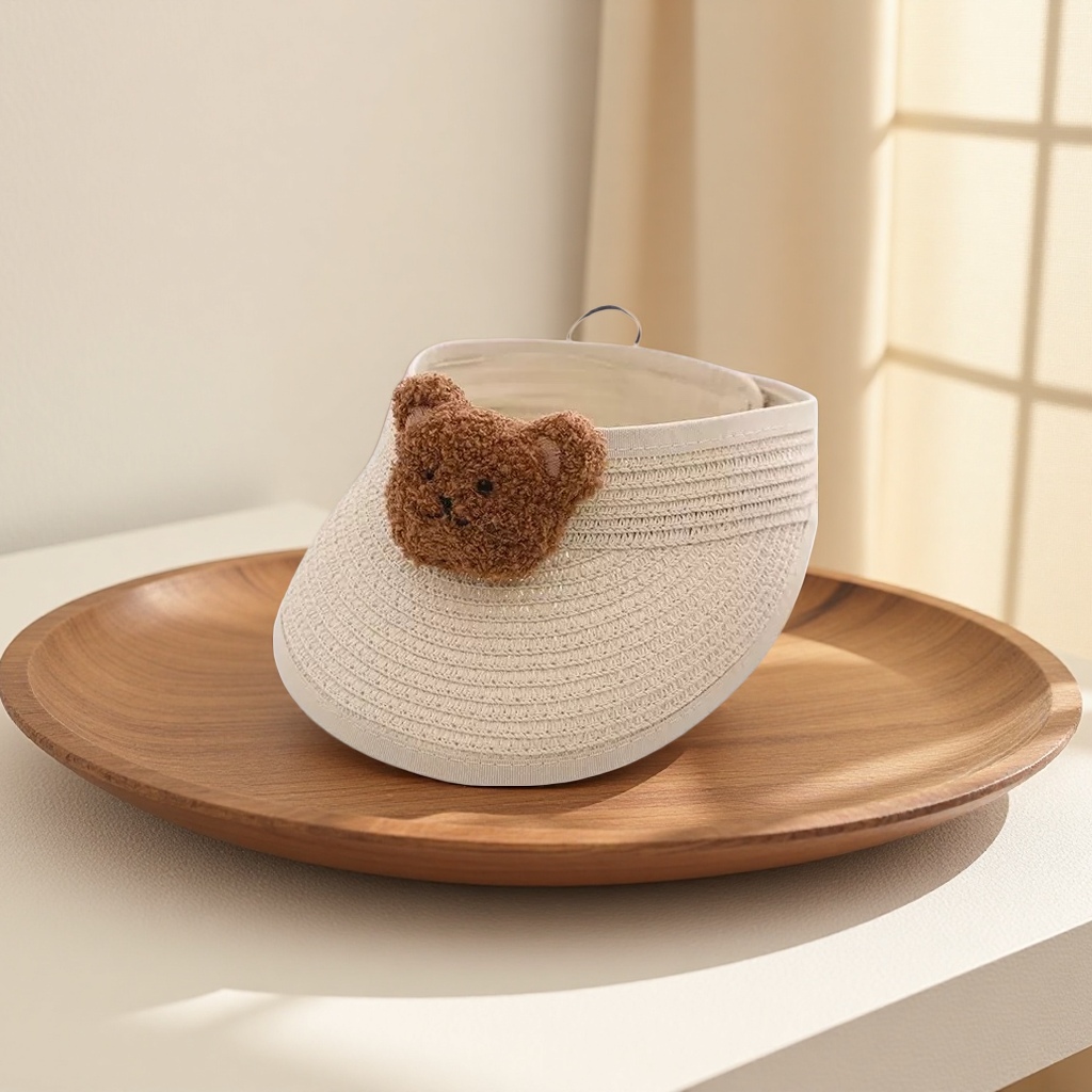 A beige straw-woven sun hat paired with a brown bear plush decorated summer sun protection hat details Picture