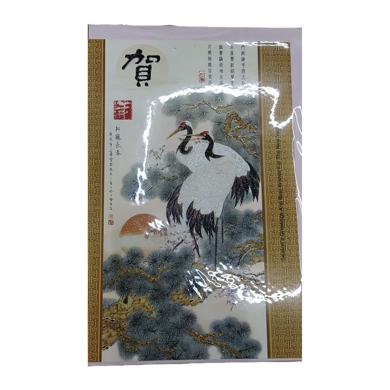 带有松鹤延年图案的贺卡，为两只白鹤立于松树间，背景有红日与松枝，卡片上有“贺”字及竖排祝福文字，边缘饰以传统回纹边框白底实物图