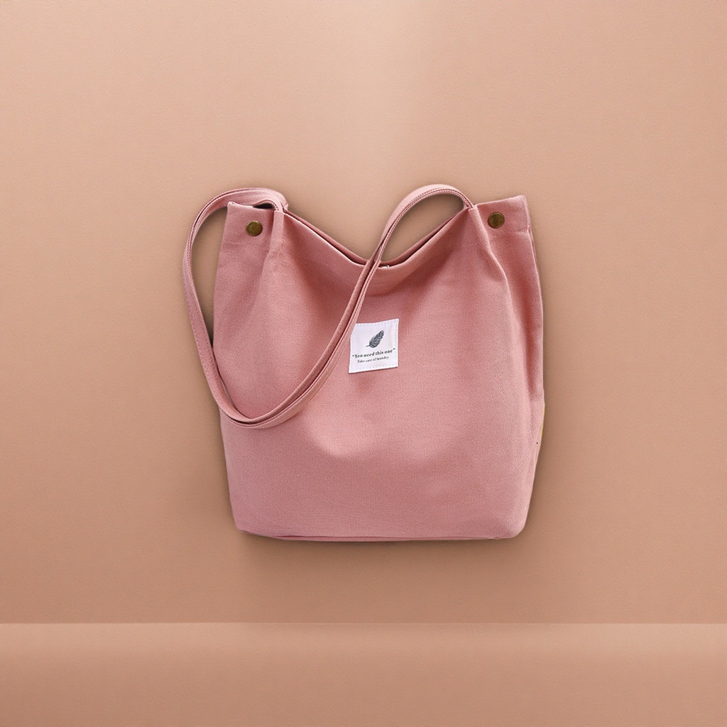 The pink canvas bag is simple, versatile, easy to carry on the shoulder, and features a niche design for commuting and casual wear