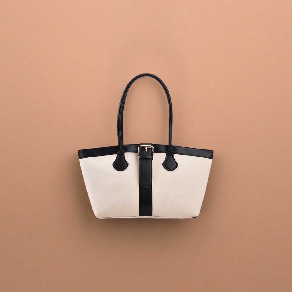 A casual single-shoulder bag in off-white canvas with a black leather handle decorative strap details Picture