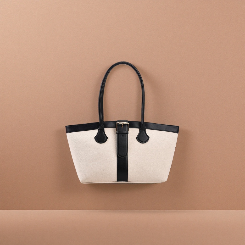 A casual single-shoulder bag in off-white canvas with a black leather handle decorative strap