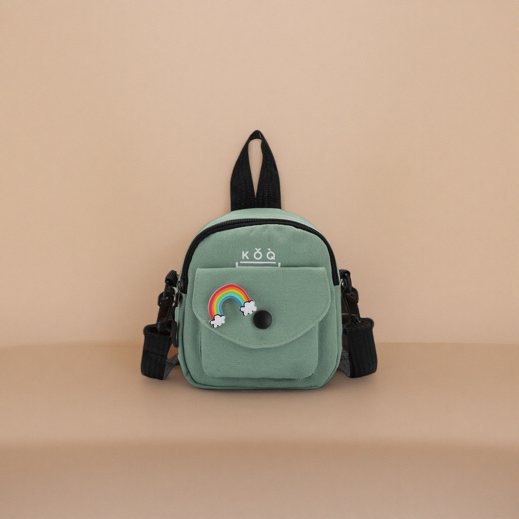 The green canvas small backpack has a rainbow cloud badge on the front, a black snap button and a black shoulder strap handle Specification image