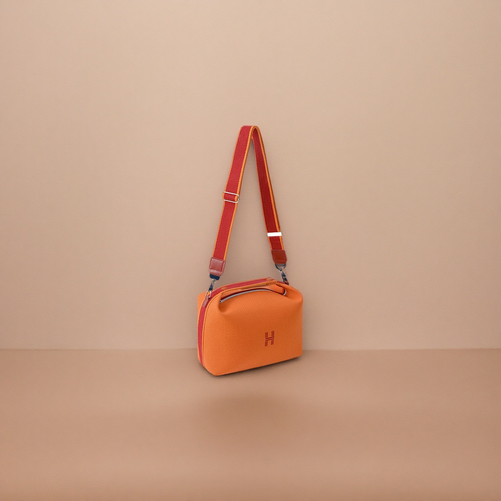 A fashionable women's single-shoulder bag with an orange handbag and a red striped shoulder strap details Picture