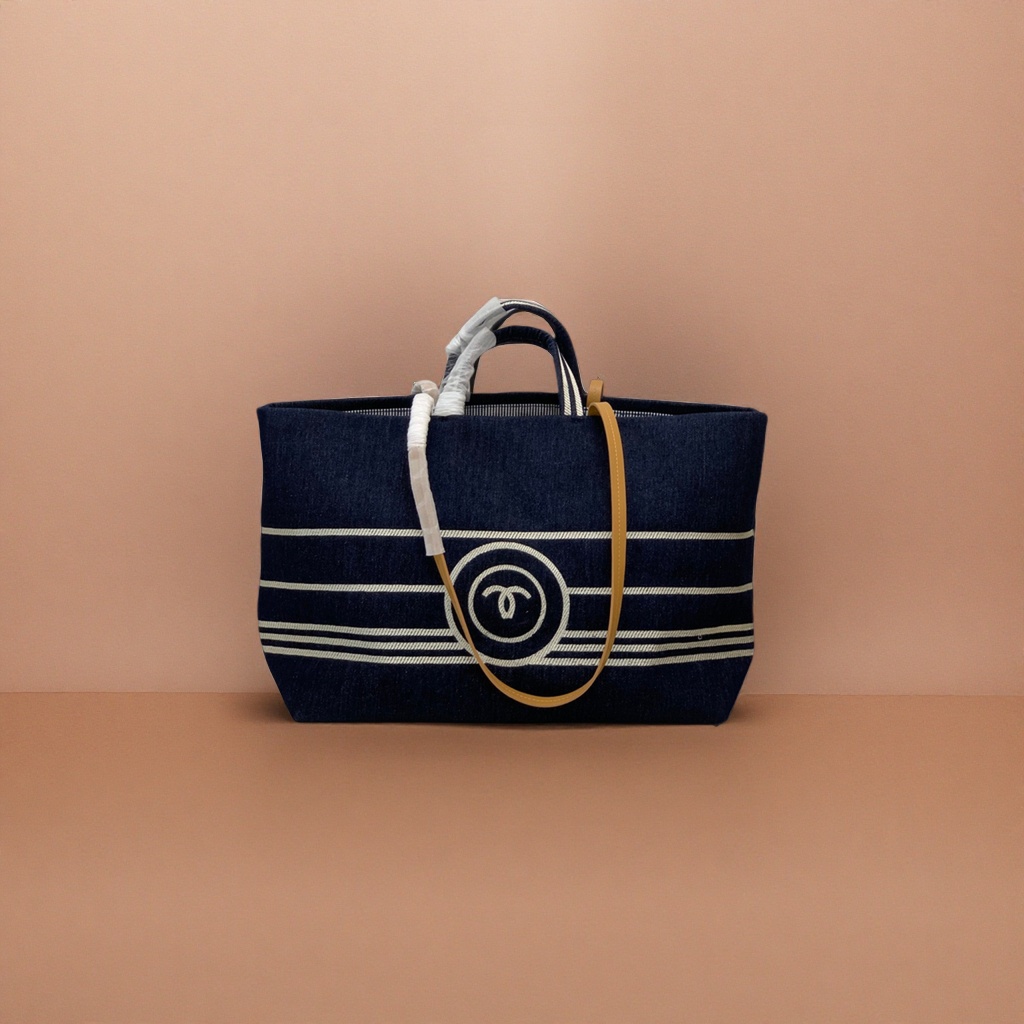 A dark blue striped canvas handbag with a beige shoulder strap and a white double C logo