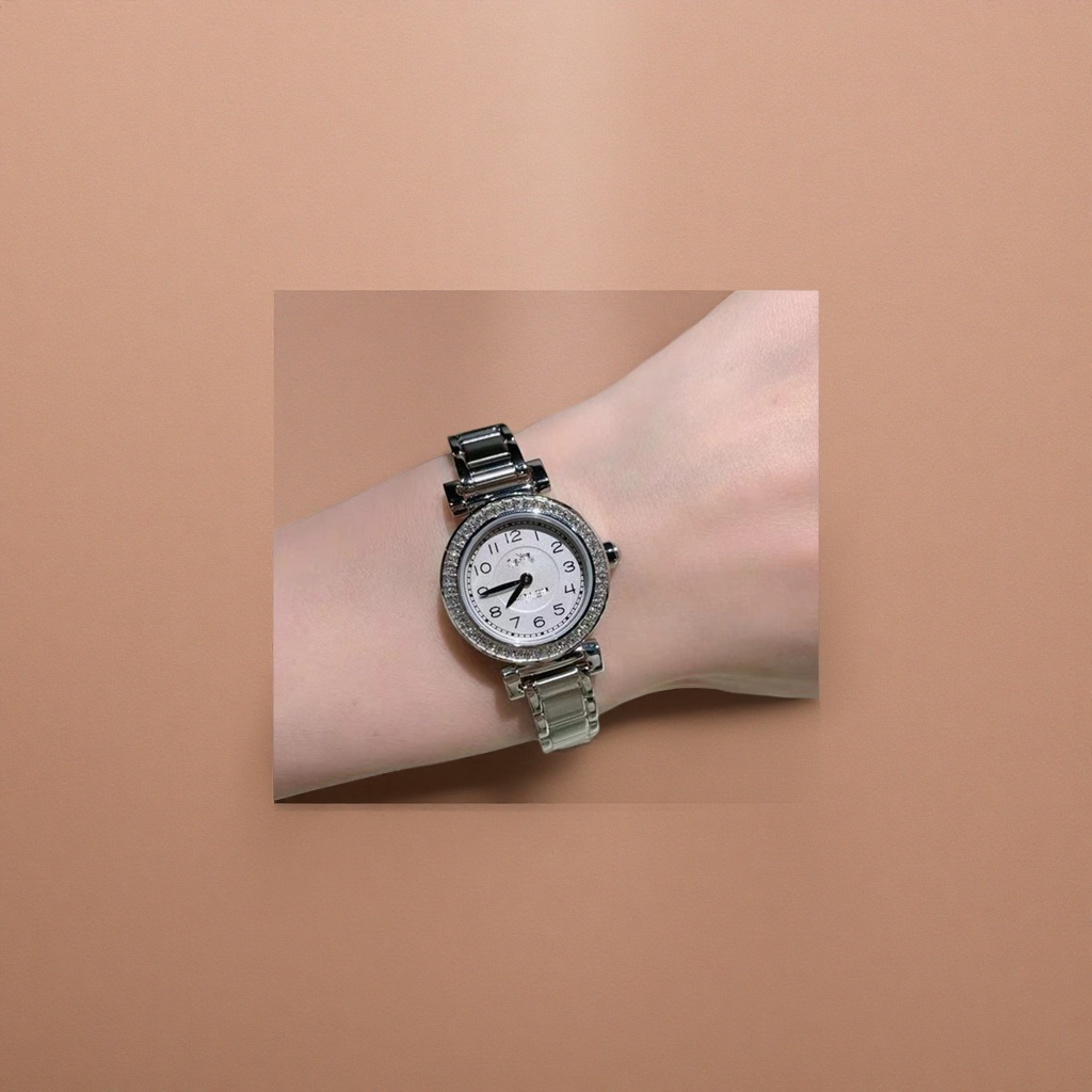 The silver diamond-encrusted women's fashion wristwatch is worn on the wrist