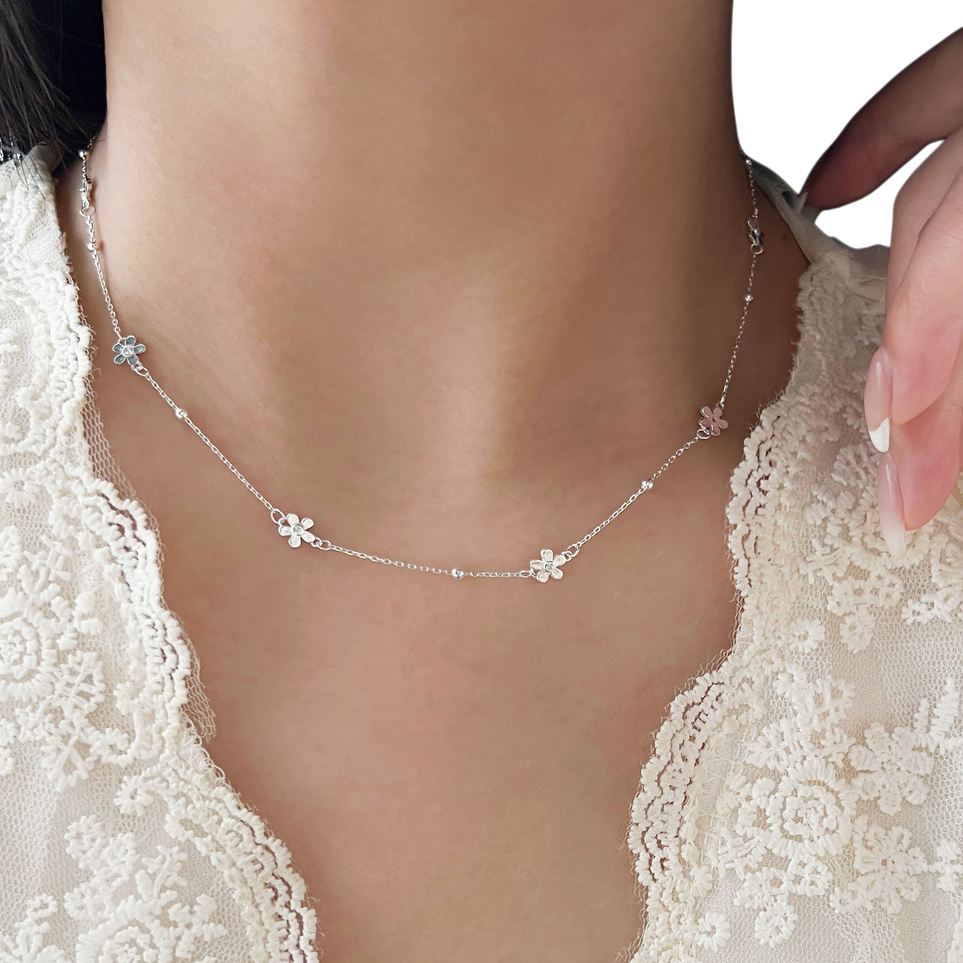 ترتدي المرأة قلادة فضية على عنقها Item Picture