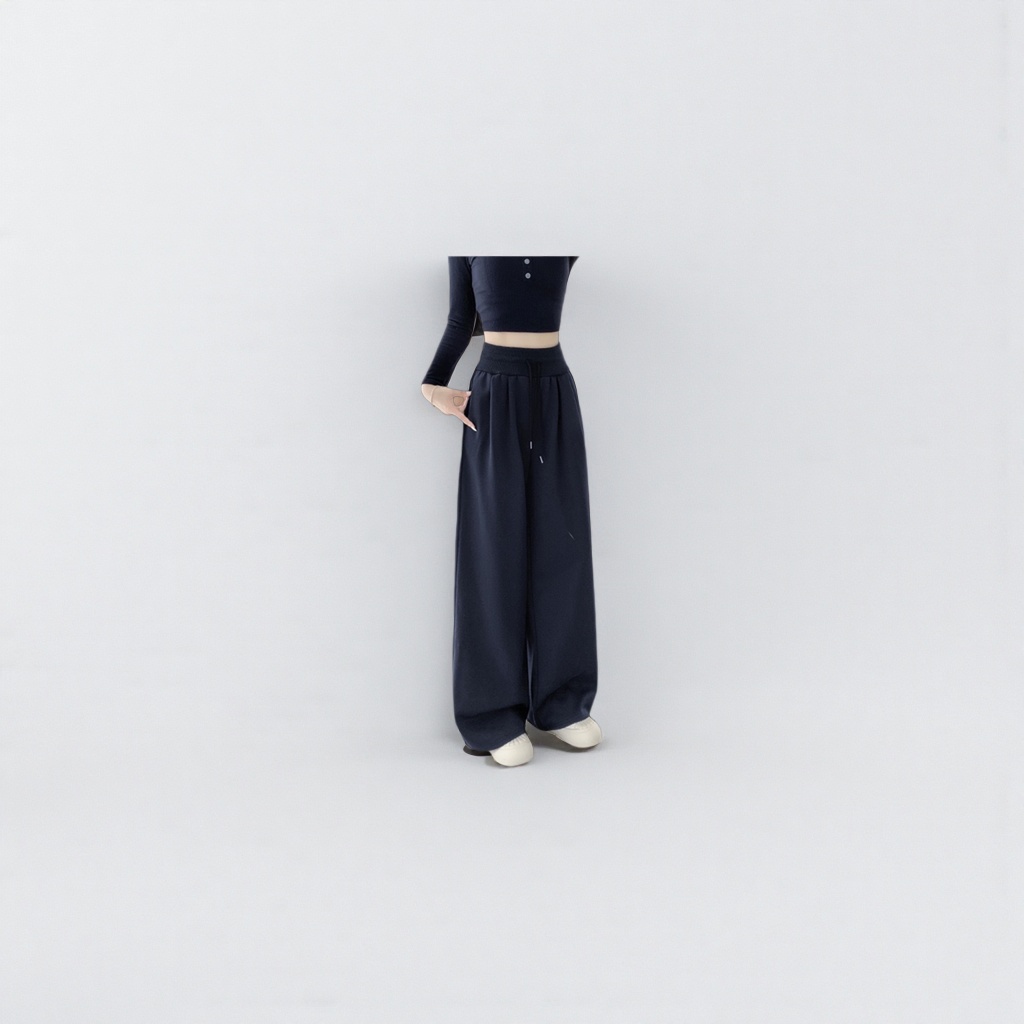 A model's outfit featuring navy blue long wide-leg pants, a deep blue high-waisted top paired with white sports shoes