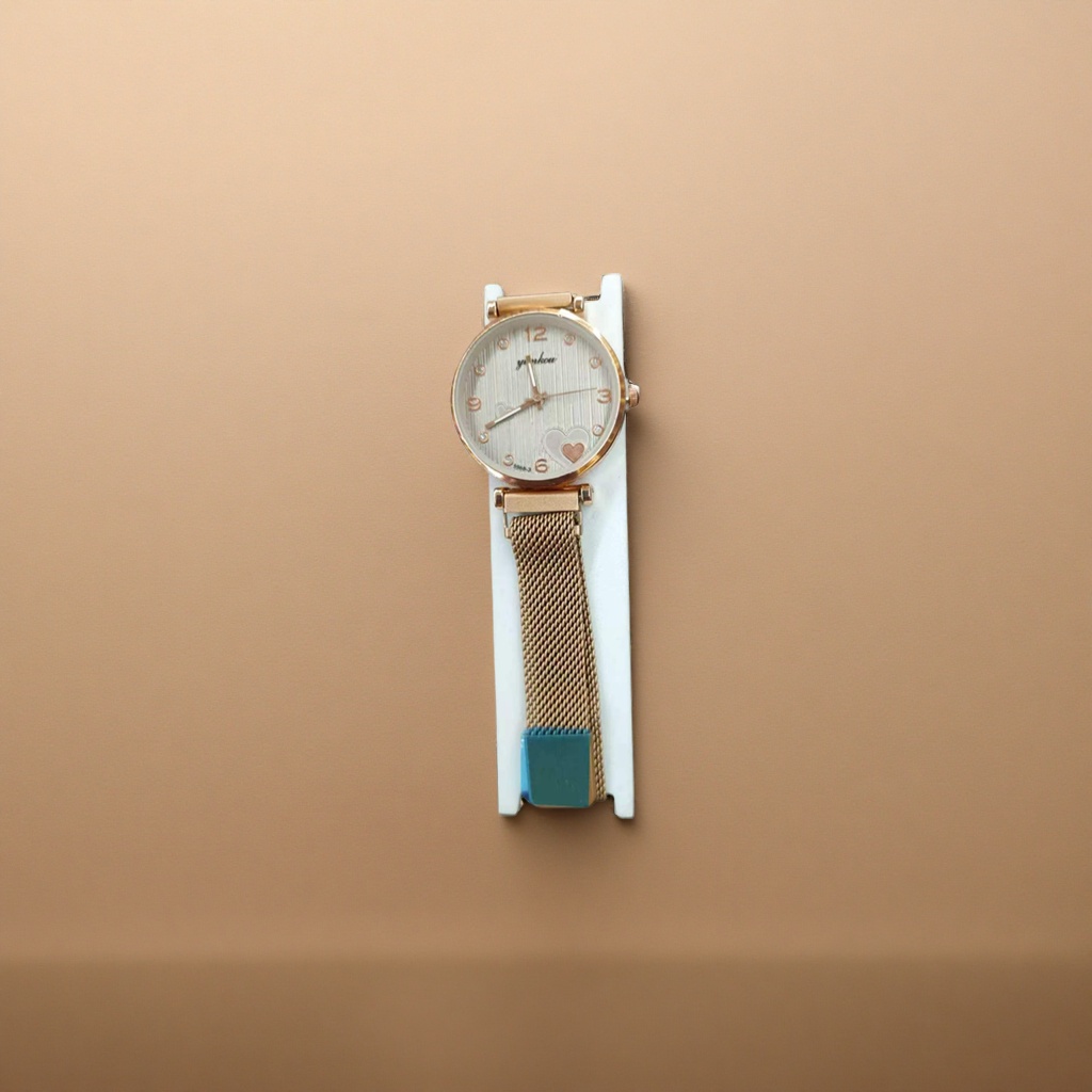 The watch features a golden case with white striped heart-shaped decoration and a metal mesh strap with a white stand details Picture