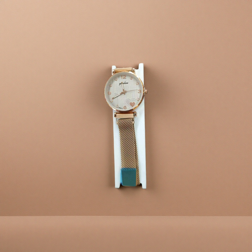 The watch features a golden case with white striped heart-shaped decoration and a metal mesh strap with a white stand