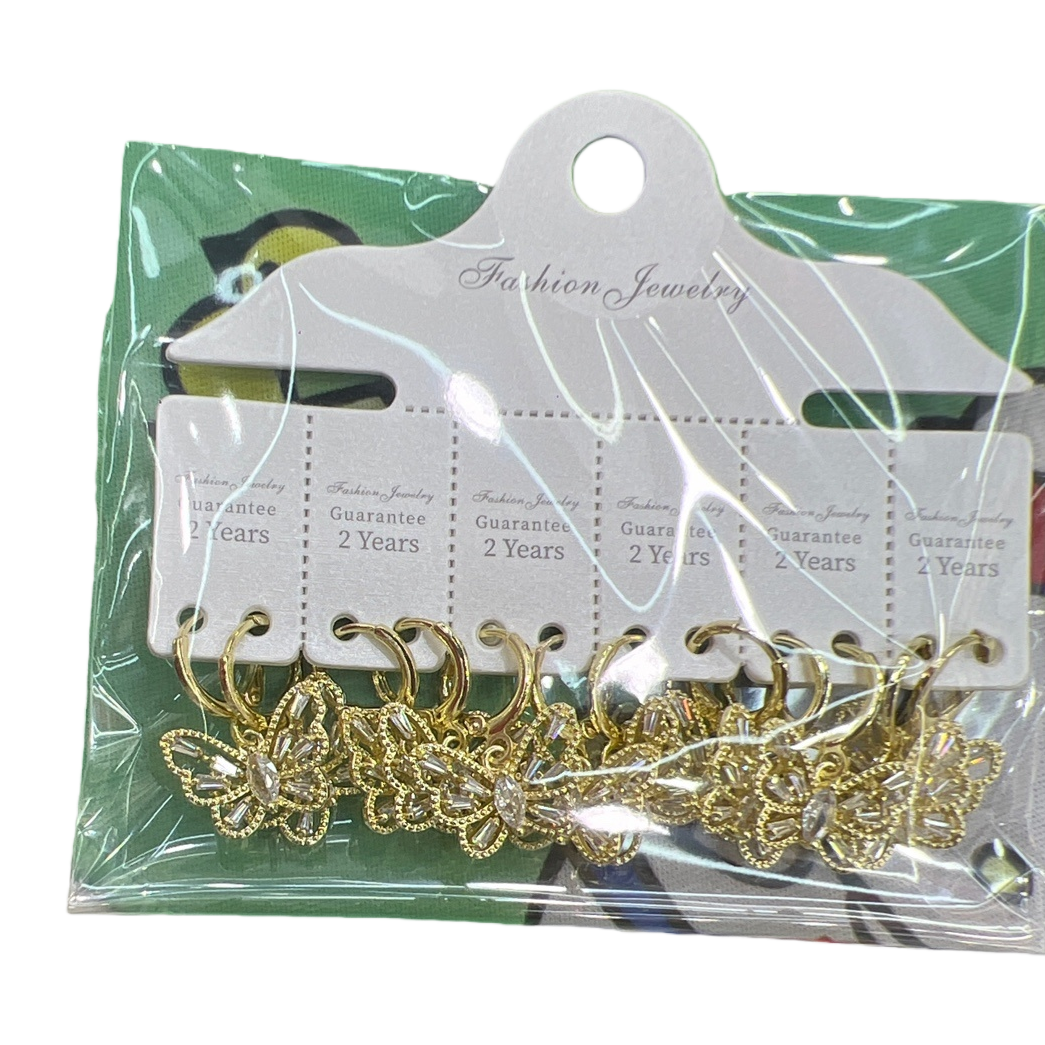Golden butterfly-shaped earrings, packaged in a transparent plastic bag, with a white tag and a green cartoon fabric background Item Picture