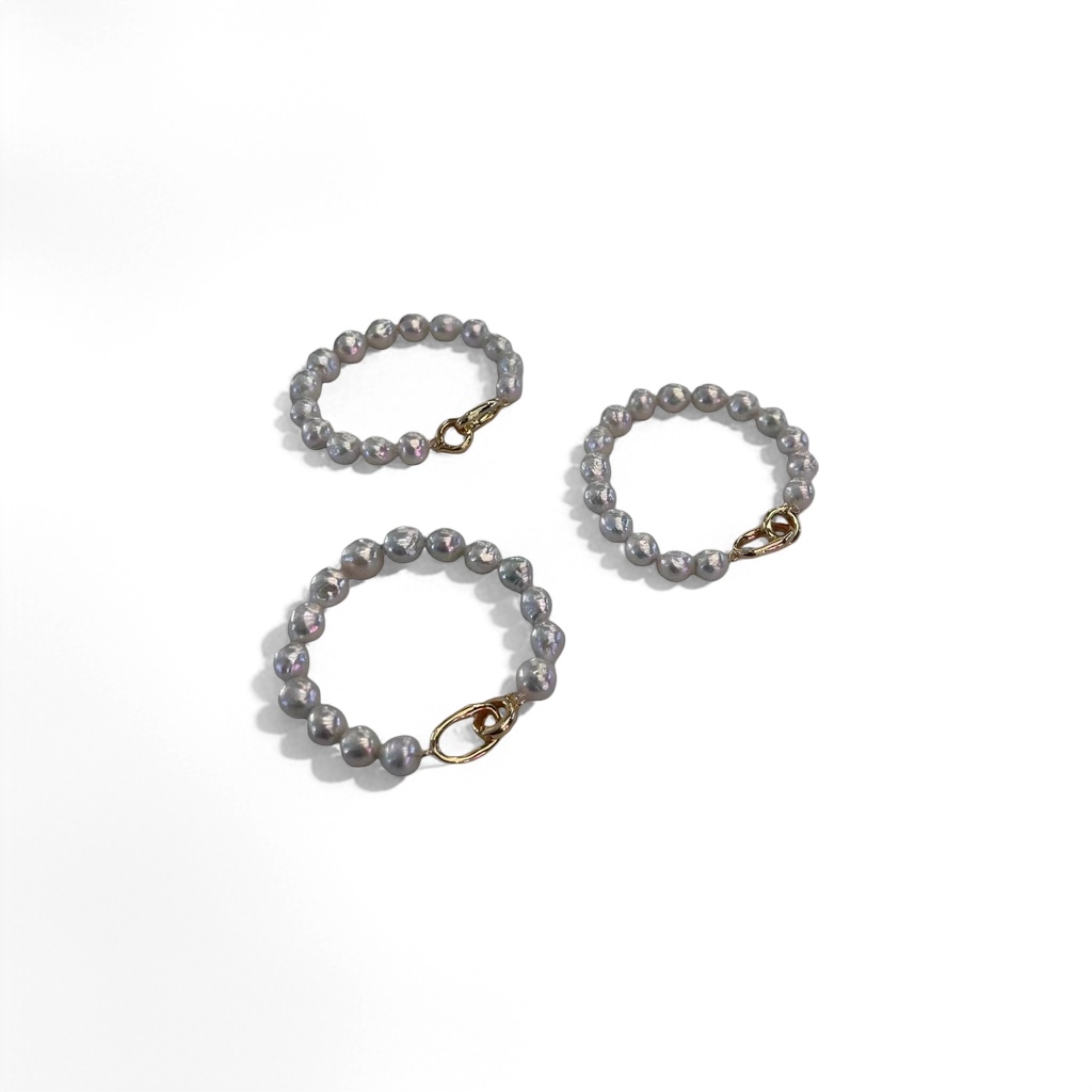A white pearl bracelet with three strings of irregular pearls and golden buckles details Picture